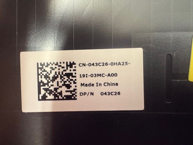 Metallic label with QR code and text on a black surface